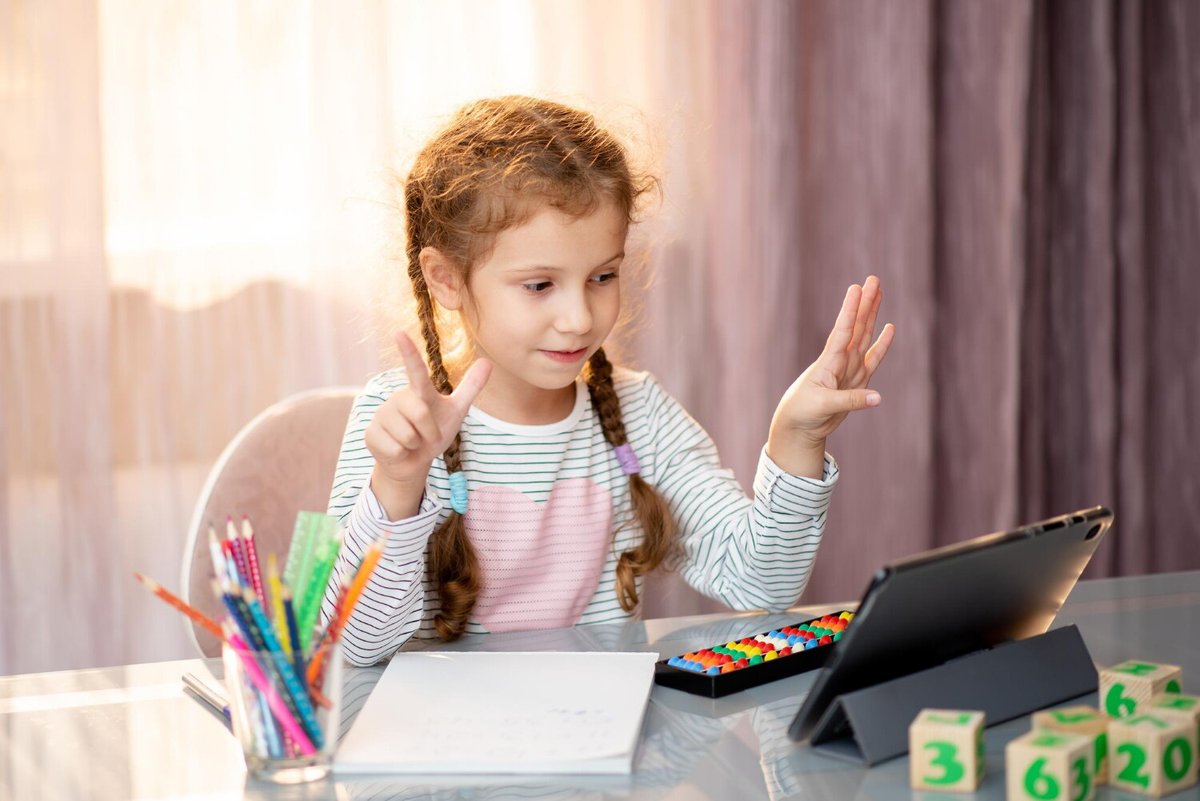 Девочка учится читать за планшетом